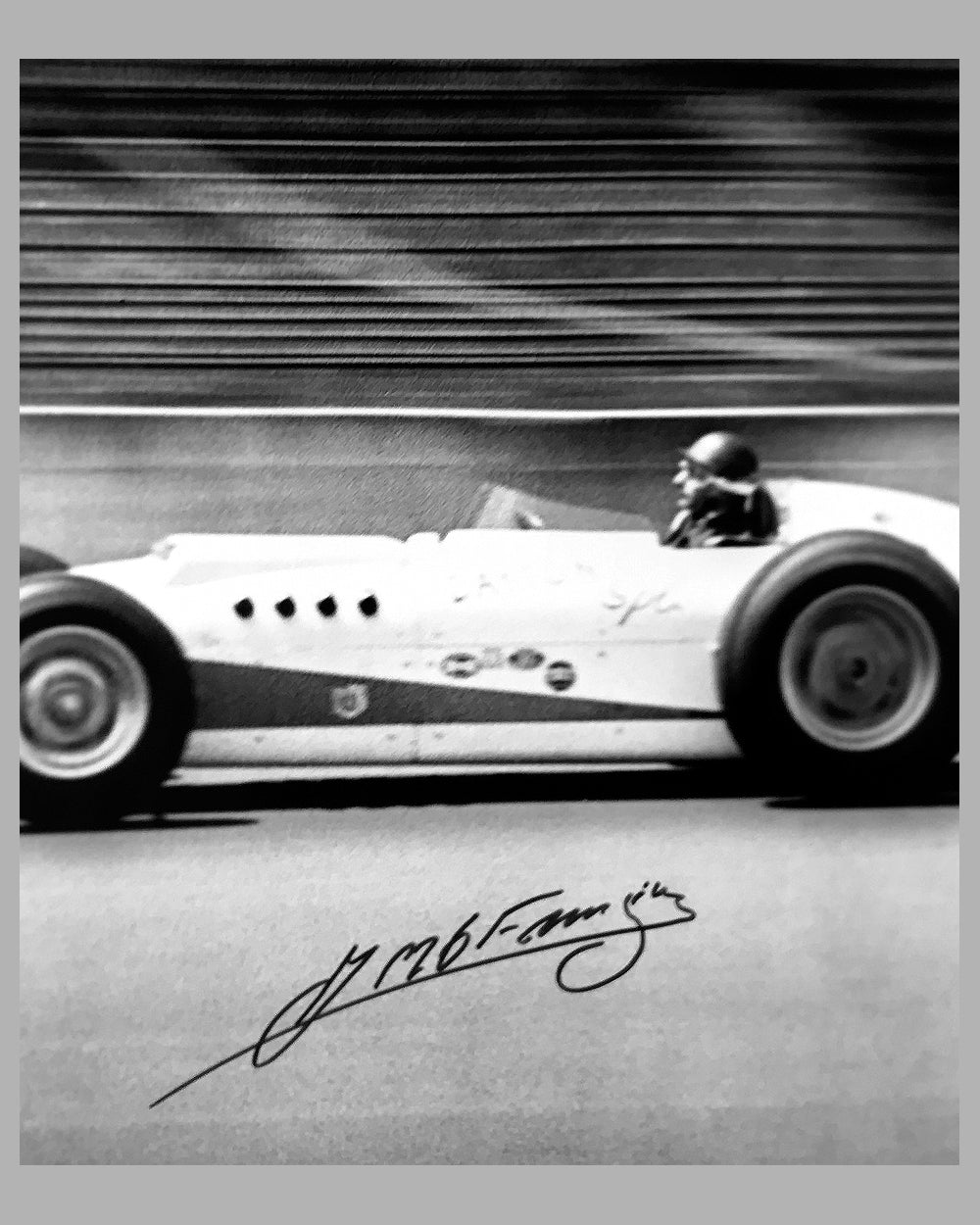 Juan Manuel Fangio testing a Kurtis Offenhauser car in 1958 b&w photograph autographed by Fangio 2