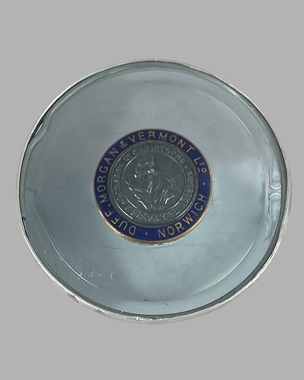 Saint Christopher medal mounted on a U.K. registration window sticker