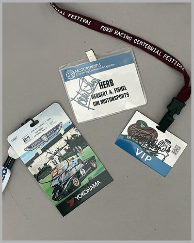 Three Herb Fishel credentials, autographed by Shelby, Stewart, Ickx, and Gurney