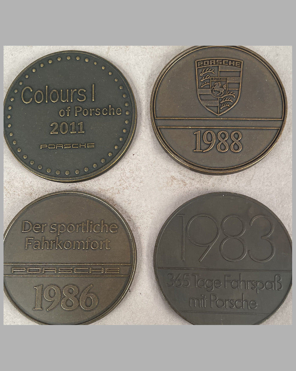 Four yearly bronze coins from the Porsche factory, 1983, 1986, 1988, and 2011 4