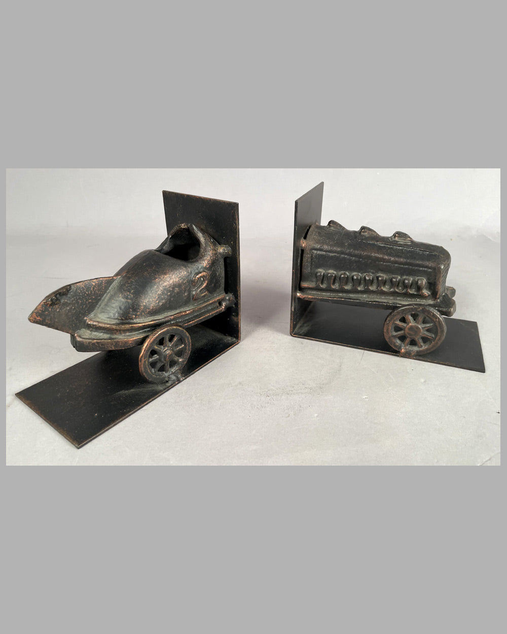 Pair of bronze book ends with primitive racing car motif 3