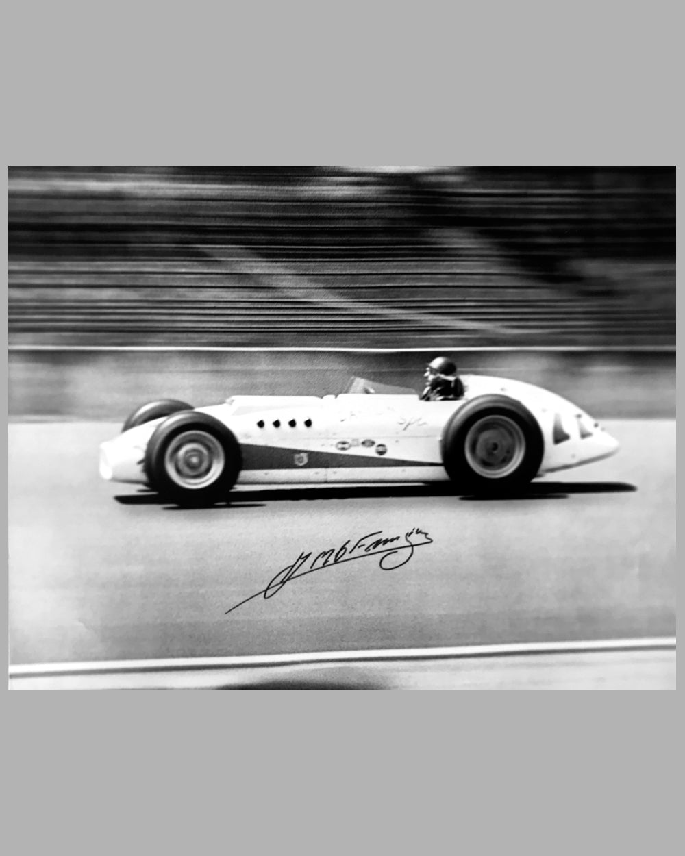 Juan Manuel Fangio testing a Kurtis Offenhauser car in 1958 b&w photograph autographed by Fangio