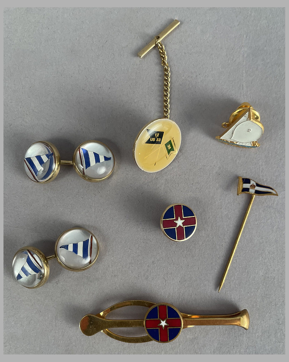 Collection of lapel pins, cuff links and tie clip form yacht clubs and events